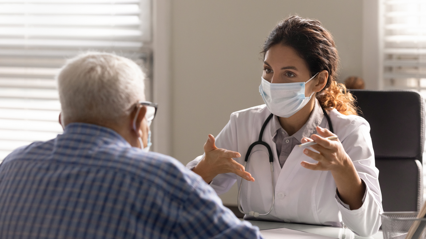 Provider explaining care to an elderly male patient